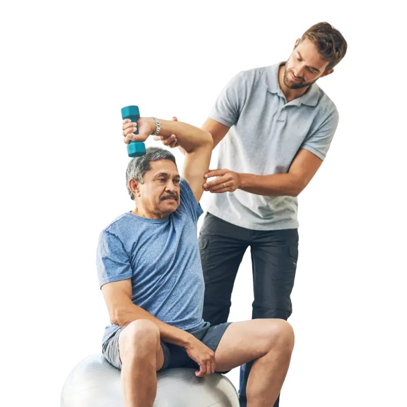 Physiotherapist guiding a patient seated on an exercise ball, dumbbell in hand