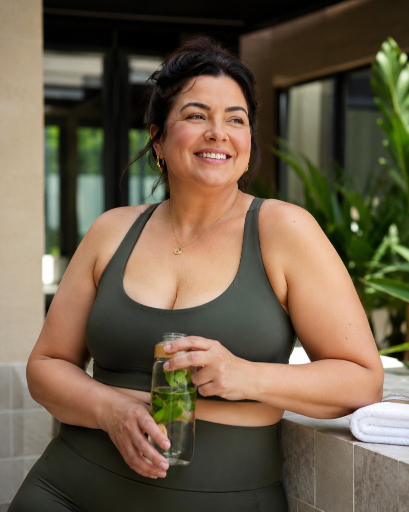 Femme souriante en tenue sportive, hydratation et bien-être au quotidien