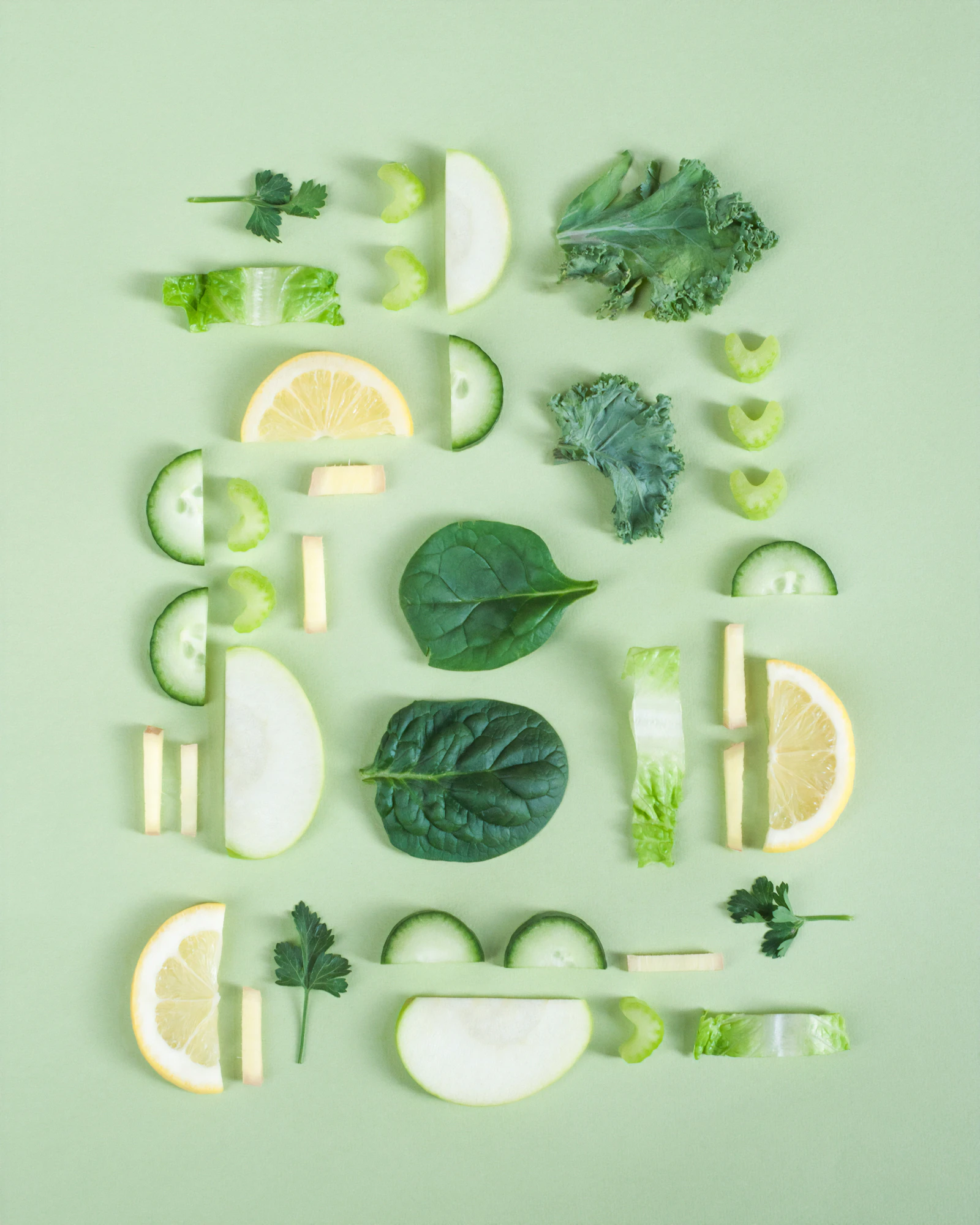 Légumes verts, herbes et rondelles de citron disposés sur un fond vert